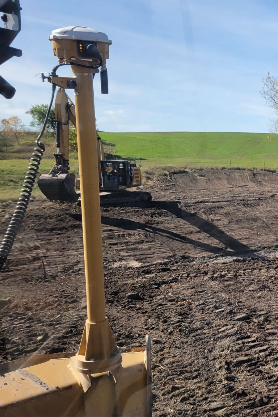 3D GPS receiver mounted on a dozer blade mast at a culvert jobsite