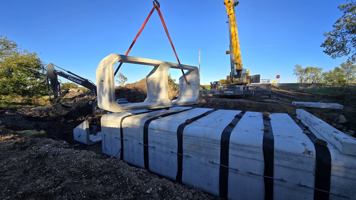 Crane lifting a precast box culvert section into place