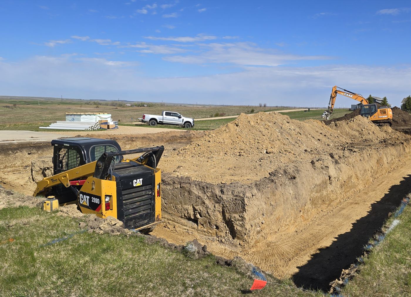Stateline Excavating skid steer and excavator at a trench excavation