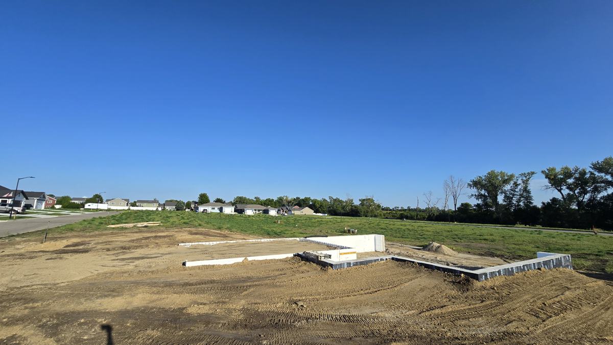 New foundation with graded backfill around it on a residential lot