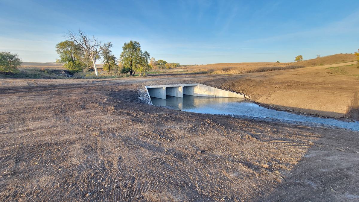 Completed cast-in-place triple-barrel box culvert road crossing with graded banks